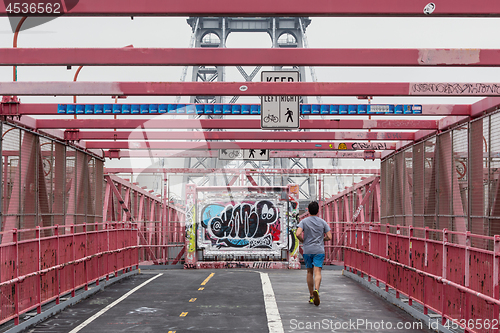Image of Unrecognizable sporty recreational male runner funning at Williamsburg bridgein New York City, USA