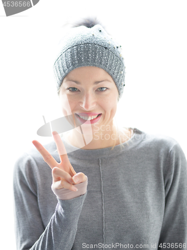Image of Close up portrait of cheerful caucasian woman, gesturing peace sign and smiles