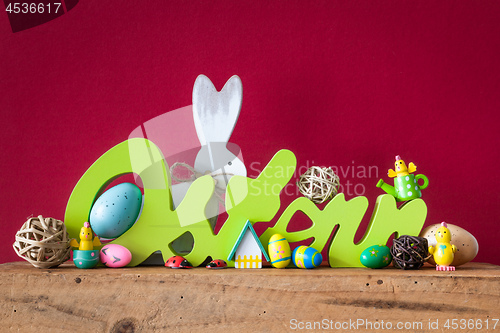 Image of Word Easter in german language with easter bunny eggs and chicks