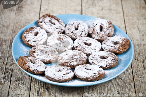 Image of Fresh baked chocolate chip cookies with sugar powder on blue pla