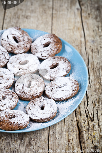 Image of Fresh baked chocolate chip cookies with sugar powder on blue pla