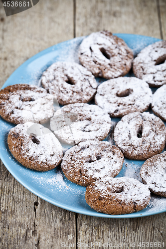 Image of Fresh baked chocolate chip cookies with sugar powder on blue pla