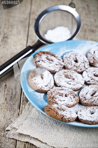 Image of Fresh baked chocolate chip cookies with sugar powder on blue pla