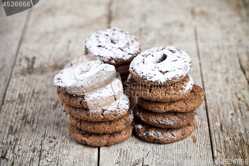 Image of Fresh baked chocolate chip cookies with sugar powder stacks on w