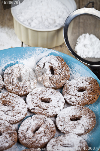 Image of Fresh baked chocolate chip cookies with sugar powder on blue pla