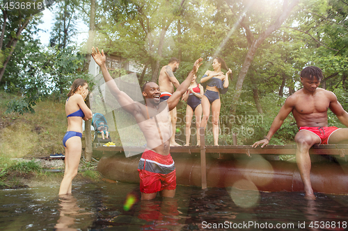 Image of Enjoying river party with friends. Group of beautiful happy young people at the river together