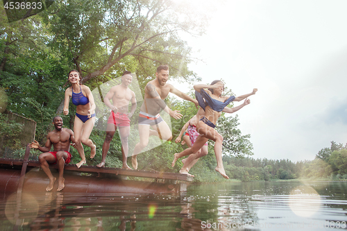 Image of Enjoying river party with friends. Group of beautiful happy young people at the river together