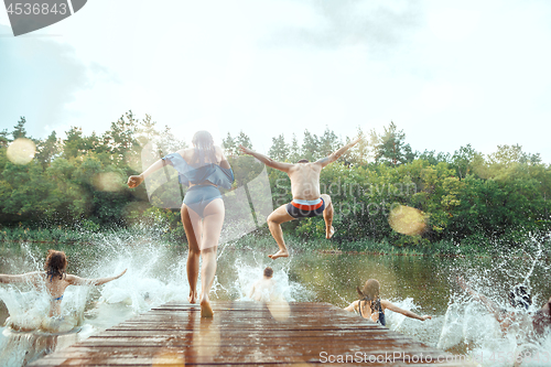 Image of Enjoying river party with friends. Group of beautiful happy young people at the river together