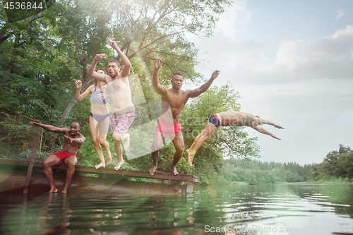 Image of Enjoying river party with friends. Group of beautiful happy young people at the river together