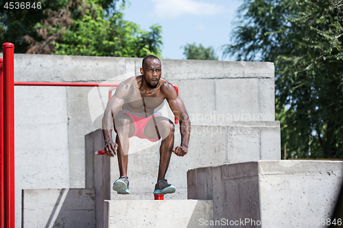 Image of Athlete doing exercises at stadium