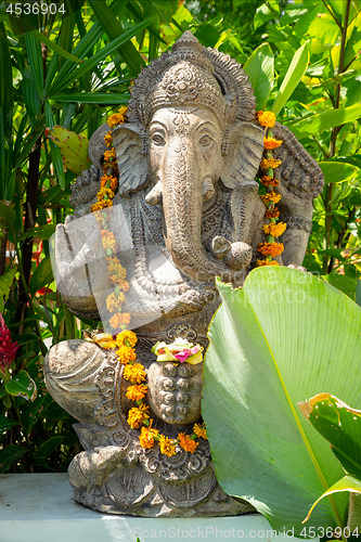 Image of Garland of golden flowers draped around Ganesha