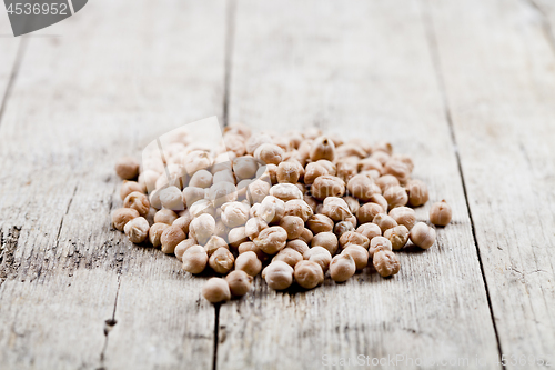 Image of Dry raw organic chickpeas heap on rustic wooden table background