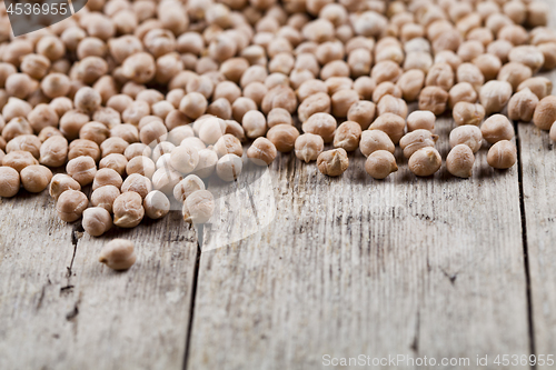 Image of Dry raw organic chickpeas heap on rustic wooden table background