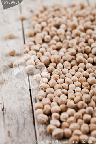 Image of Dry raw organic chickpeas heap on rustic wooden table background