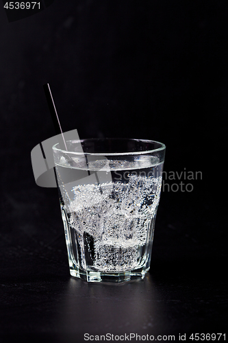 Image of Glass of fresh cold carbonated water with ice cubes.