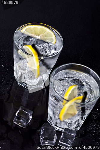 Image of Glasses of fresh cold carbonated water with ice cubes and lemon 