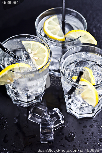 Image of Three glasses with fresh cold carbonated water with lemon slices