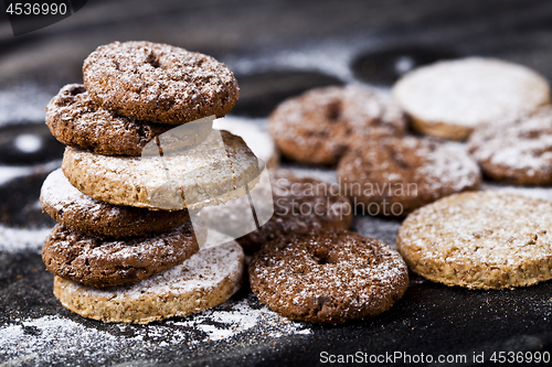 Image of Chocolate chip and oat fresh cookies with sugar powder stack.