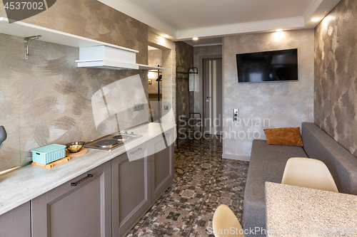 Image of The interior of a small living room and kitchen in the hotel room.