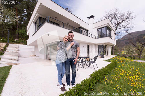 Image of couple hugging in front of  new luxury home