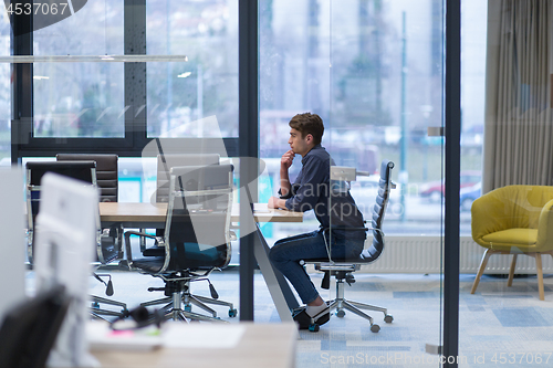 Image of young businessman relaxing at the desk