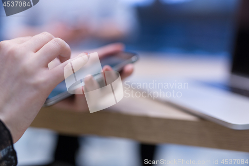 Image of Elegant Woman Using Mobile Phone in startup office building