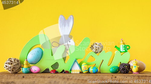 Image of Word Easter in german language with easter bunny eggs and chicks