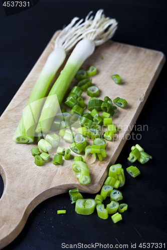 Image of Fresh green organic chopped onions on a cutting board.