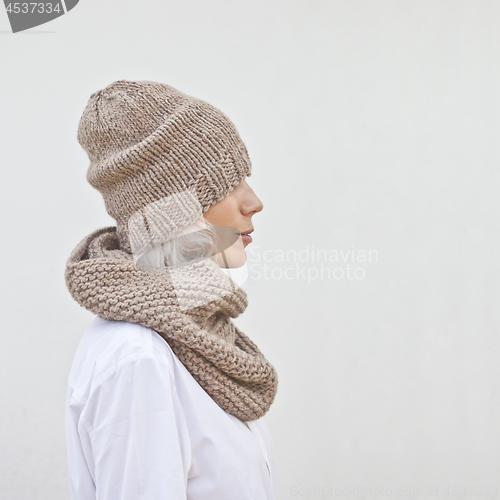 Image of Pretty young woman in warm brown knitted hat and snood.