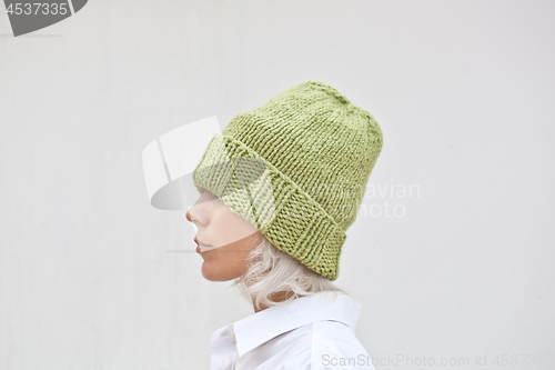 Image of Pretty young woman in warm green knitted hat.