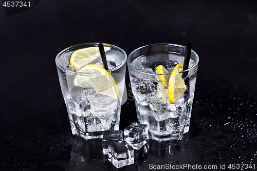Image of Glasses of fresh cold carbonated water with ice cubes and lemon 