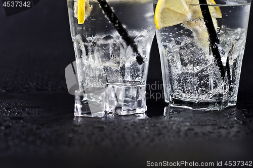 Image of Glasses of fresh cold carbonated water with ice cubes and lemon 