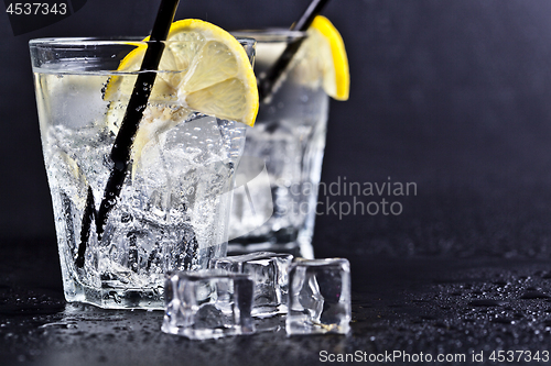 Image of Glasses of fresh cold carbonated water with ice cubes and lemon 