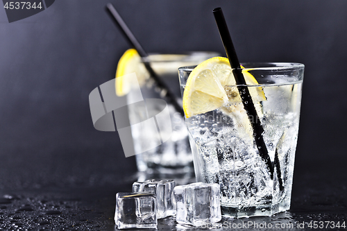 Image of Glasses of fresh cold carbonated water with ice cubes and lemon 