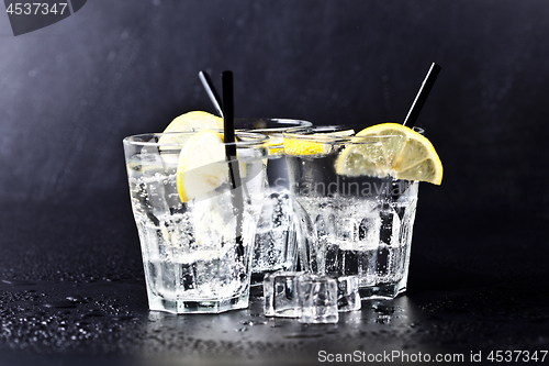 Image of Three glasses of fresh cold carbonated water with ice cubes and 