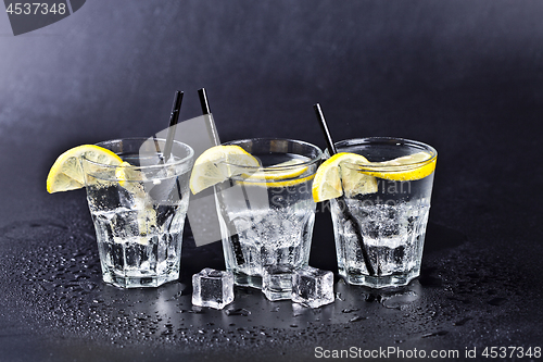 Image of Three glasses of fresh cold carbonated water with ice cubes and 