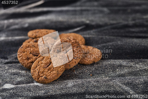 Image of Double chocolate chip fresh cookies heap on black background.