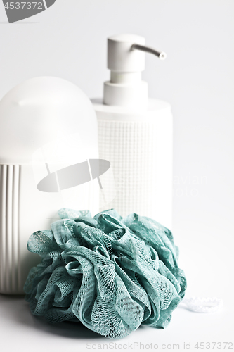 Image of Bath cosmetic products and green sponge on light background.