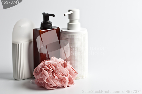 Image of Bath cosmetic products and white sponge on light background.