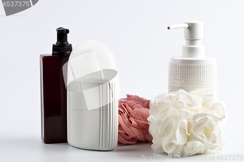 Image of Bath cosmetic products and sponges on light background. 