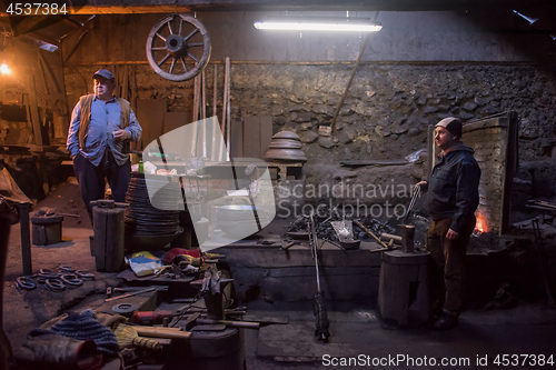 Image of portrait of two generations traditional blacksmith