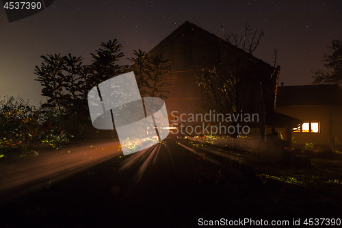 Image of the house with the burning window at night