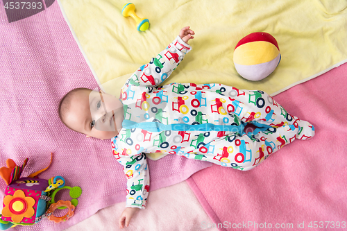 Image of top view of newborn baby boy lying on colorful blankets