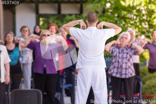 Image of trainer training motivated active healthy senior people