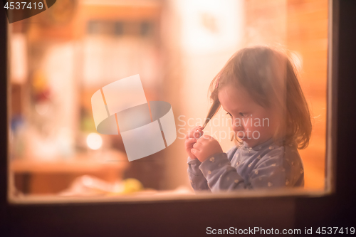 Image of little cute girl playing near the window