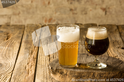 Image of Glasses of different kinds of beer on wooden background