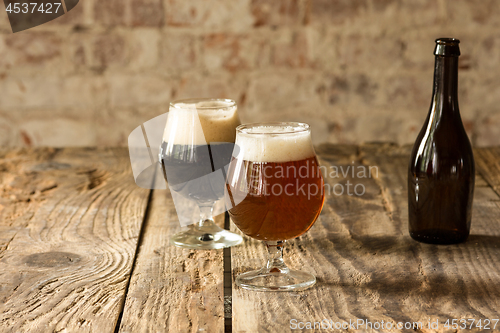 Image of Glasses of different kinds of beer on wooden background