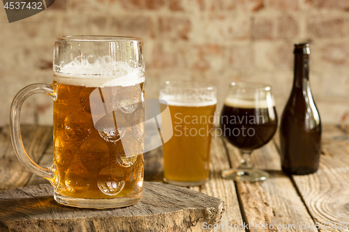 Image of Glasses of different kinds of beer on wooden background