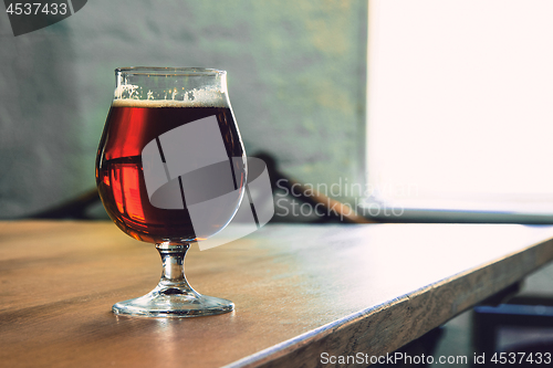 Image of Glasses of different kinds of beer on wooden background