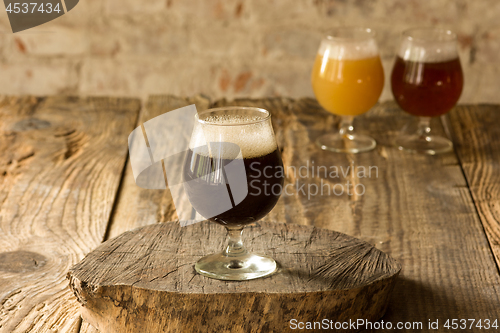 Image of Glasses of different kinds of beer on wooden background